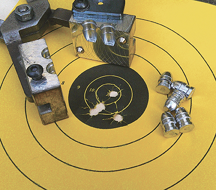 The No. 43-215C mould plus some bullets sitting on the five-shot group at 25 yards.